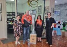 A picture of a group of people at a business in front of some of their fibreglass products